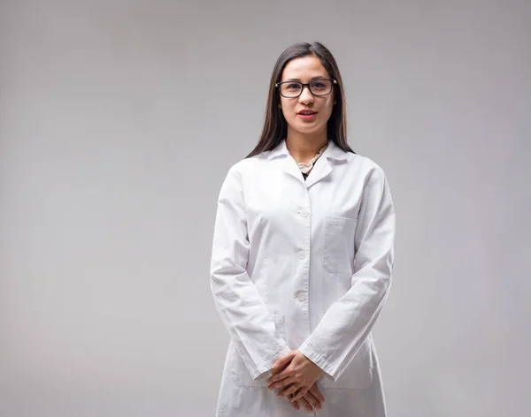 Smiling East Asian woman in glasses and a white coat. She\'s a hardworking researcher or lab technician, using her hard-earned expertise to deliver professional service