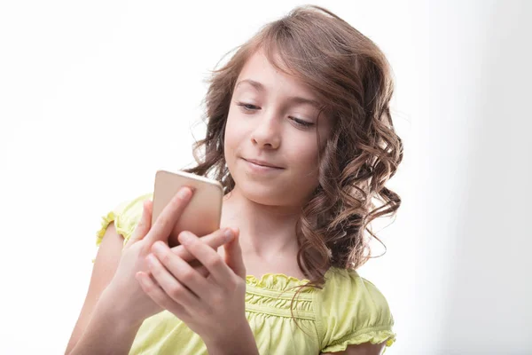 身着绿色衣服的卷发女孩善于使用智能手机 是数字时代的缩影 — 图库照片