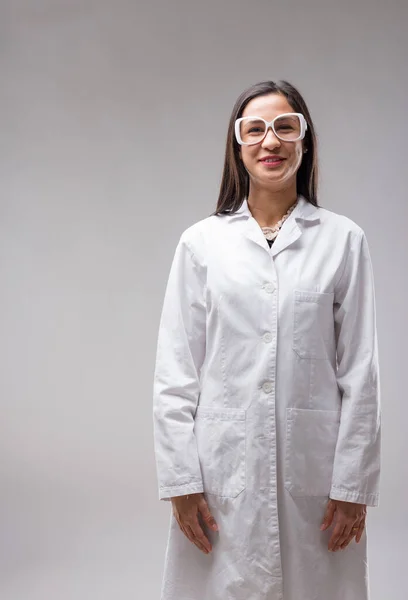 Portrait of an East Asian woman with glasses in a white lab coat, smiling. An experienced researcher or lab technician, she\'s acquired her expertise through study and hard work, providing excellent pr