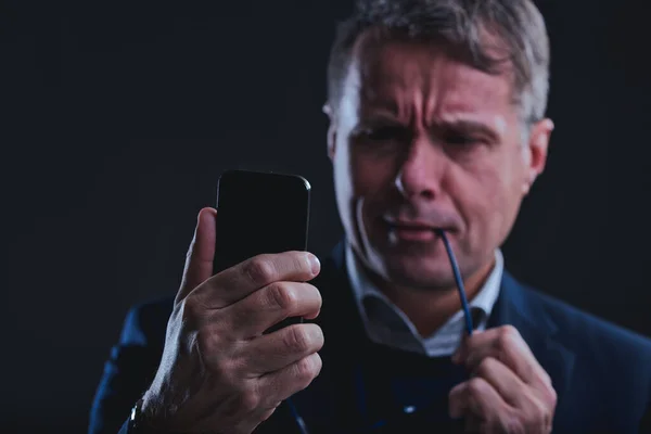 Homem Ansioso Observando Ceticamente Smartphone Enquanto Nervosamente Mordisca Braço Seus — Fotografia de Stock