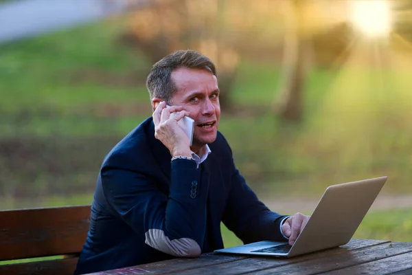 Muž Pracuje Laptopem Telefonem Parku Stále Dosažitelný Přírodním Klíně Nosí — Stock fotografie