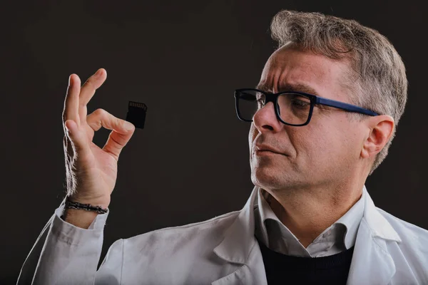 Laboratuvar Önlüğü Gözlüklü Bir Teknisyen Parmaklarının Arasındaki Hafıza Kartını Profesyonelce — Stok fotoğraf