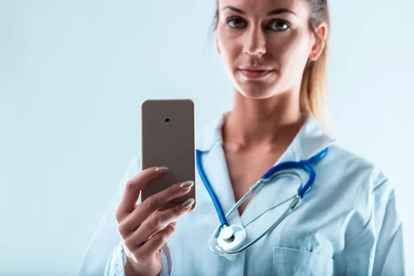 医師の手で保有するスマートフォンは モバイル経由のオンライン作業を示唆しています 利点は より少ないコミュニケーションで豊富です あなたが変更に適応することができれば あなたが決める — ストック写真