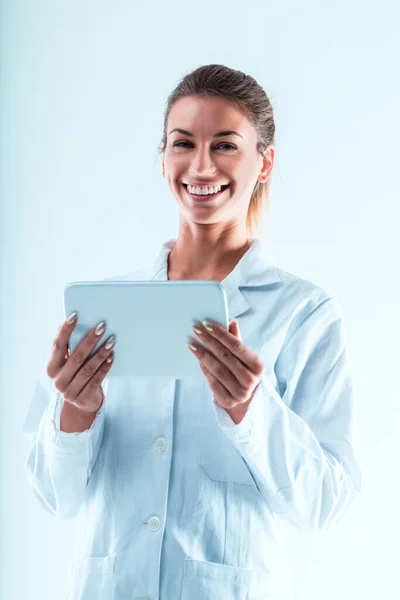 タブレットで白いコートを着た笑顔の女性は 技術や研究の専門家を体現しています 彼女はテクノロジーを使ってデータを検証し 予測ジャーナルを後押ししし アプリやインターネットを介した知識共有を促進している — ストック写真