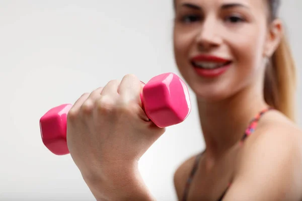 一个模糊的女人把小的粉红色的重量举到焦点上 她在健身房的轻度锻炼有助于她的快乐 改善她的生活 并产生积极的心理影响 — 图库照片