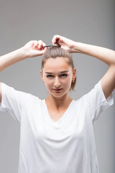 Αποφασιστική Έκφραση Μιας Νεαρής Γυναίκας Που Φτιάχνει Μαλλιά Της Ψηλή — Φωτογραφία Αρχείου