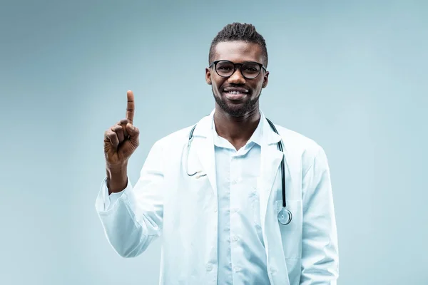Médico Negro Con Gafas Levanta Dedo Sonríe Advierte Contra Los —  Fotos de Stock