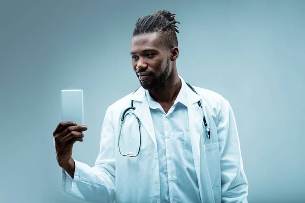의사는 스마트폰 사용량을 보여줍니다 기술이 그에게 원격으로 연락하고 신속한 지원을 — 스톡 사진