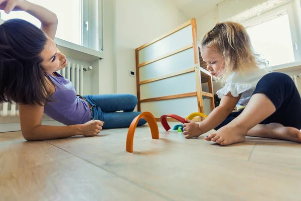 Inside a room filled with wooden toys, mother-daughter moments blossom as they play, experiment, and learn together