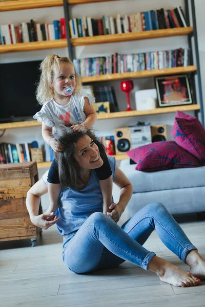 母亲和女儿在客厅里积极地玩耍 脚和身体扭打 攀爬和推挤 在充满爱心的环境中 他们通过欢乐学习身体和情感的界限 — 图库照片