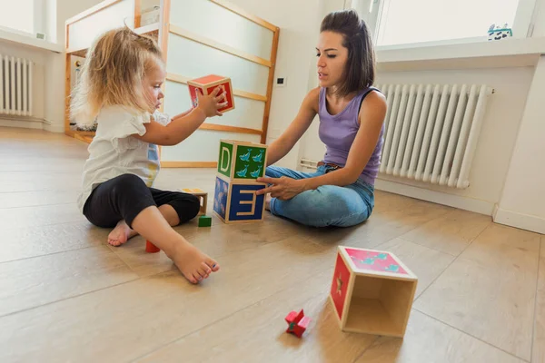 Мать Дочь Играют Детской Комнате Окруженные Деревянными Игрушками Столами Кубиками — стоковое фото