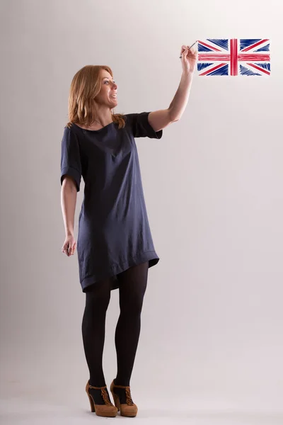 woman air-draws the English flag with a ballpoint pen, emphasizing it as the global lingua franca. 'Learning English,