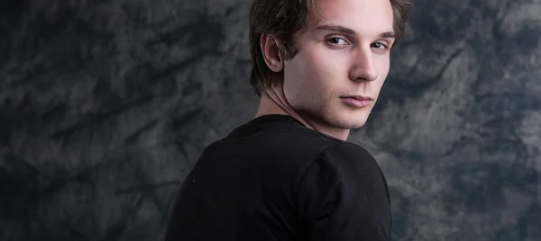 Light Brown Haired Man Black Shirt Stands Thoughtfully Grunge Blackboard — Stock Photo, Image