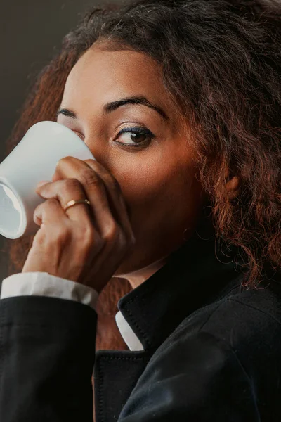 一个引人注目的黑人女人 喝着她的浓缩咖啡 凝视着她的力量 在商界和上流社会 她是一支力量 知道知识带来选择 她通过选择体现了自由 — 图库照片
