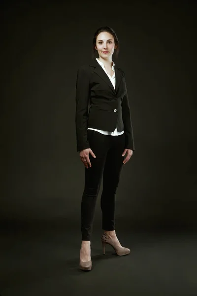 Woman Black Suit Stands Proudly Black Background Choosing High Heels — Stock Photo, Image