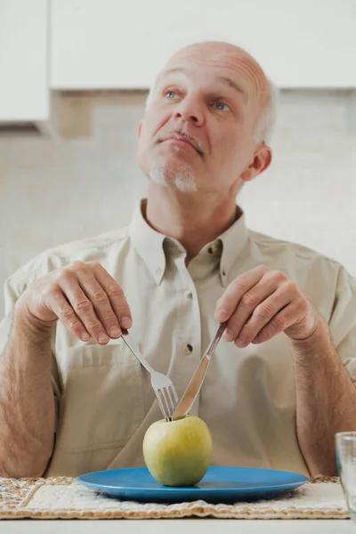 Green Apple Sits Old Man Who Poised Eat Using Utensils — Stock Photo, Image