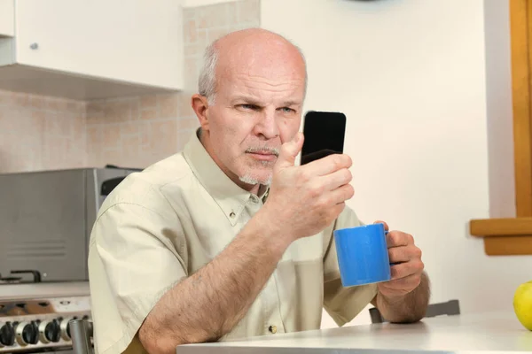 Senior Man Kitchen Squints His Smartphone Breakfast Today Phone Designs — Stock Photo, Image
