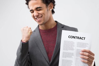 Joy radiates from a formally dressed man with a contract in hand, suggesting a successful deal clipart