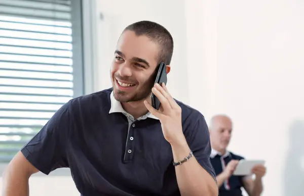 Радостный Молодой Человек Болтает Телефону Улыбка Отражает Приятный Разговор Стоковое Изображение