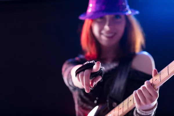 Exuberant Female Guitarist Glittery Purple Hat Points Confidently Vibrant Performance — Stock Photo, Image
