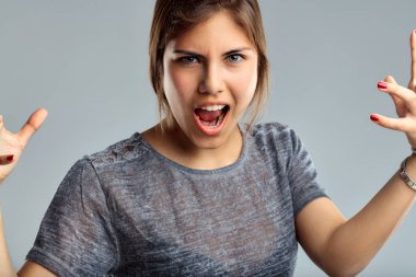 Young woman makes a roaring gesture, expressing ferocity and playful aggression clipart