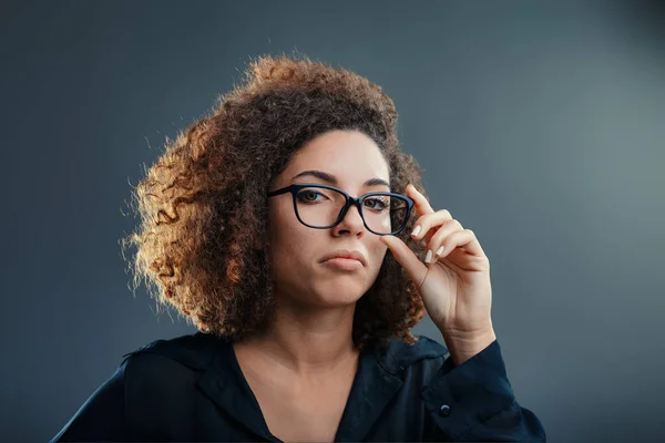Woman Adjusting Her Glasses Her Expression Mixing Curiosity Hint Skepticism — Stock Photo, Image
