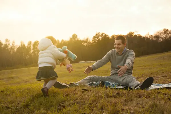 stock image Outdoor laughter fills the air as a toddler approaches her waiting father, the bond between them unmistakable