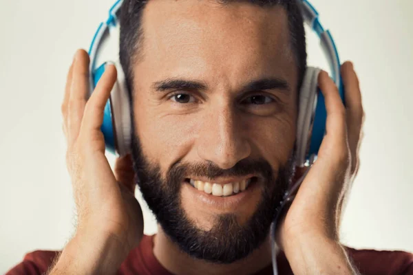 通过蓝色耳机与音乐打交道的男人散发着幸福 — 图库照片