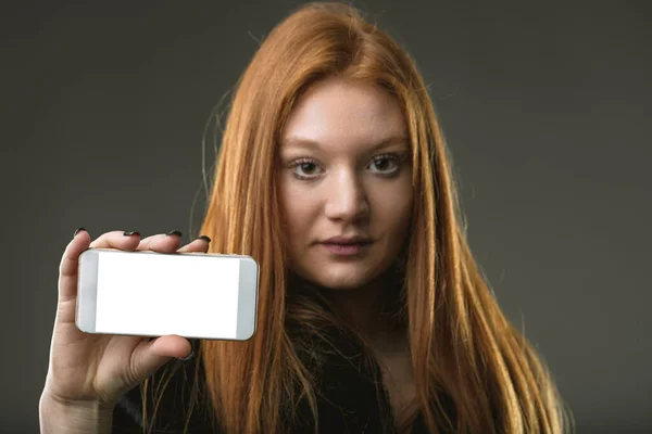 Red-haired individual with a blank phone screen, ready to showcase innovative technology