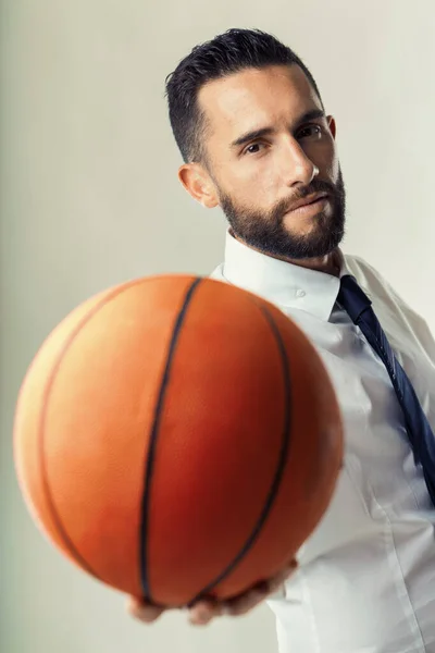 Businessman with a basketball demonstrates the balance of strategic thinking and physical agility