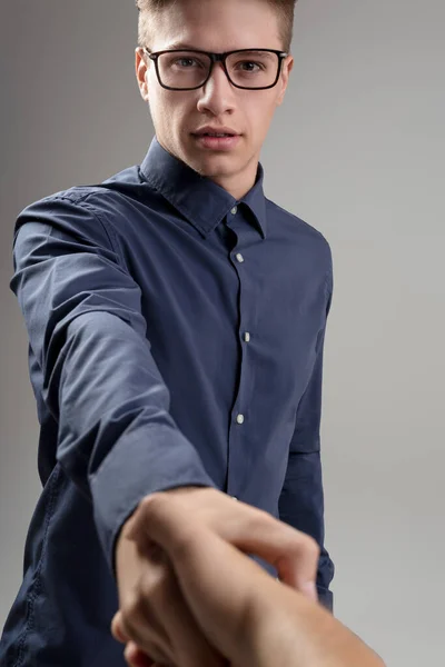 Young Professional Extends Handshake His Sharp Blue Shirt Glasses Suggesting — Stock Photo, Image