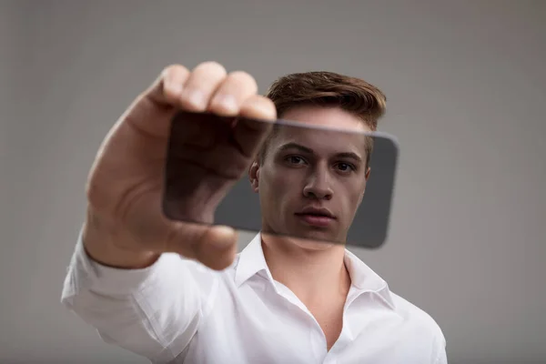 Man White Shirt Showcases Transparent High Tech Smartphone Symbolizing Cutting — Stock Photo, Image