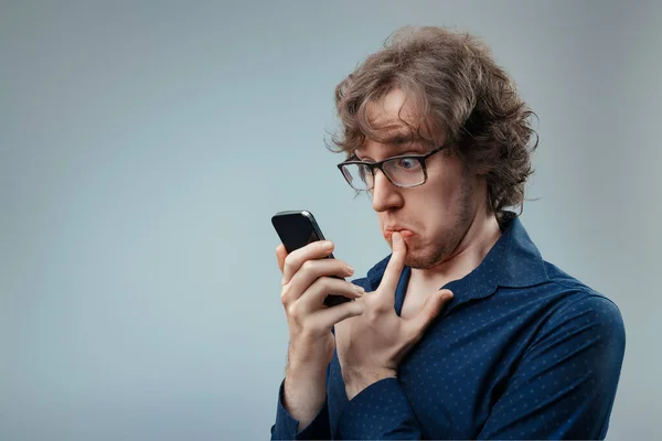Curly Haired Person Scrutinizes Phone His Wary Demeanor Showing Resistance — Stock Photo, Image