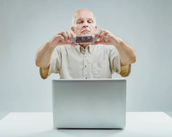Homem Concentrado Senta Com Laptop Smartphone Mão Meticulosamente Capturando Filmando — Fotografia de Stock