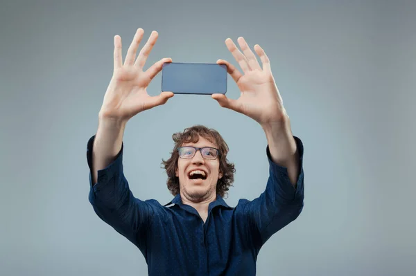 Man Blue Shirt Joyously Holds Transparent High Tech Phone Marveling — Stock Photo, Image