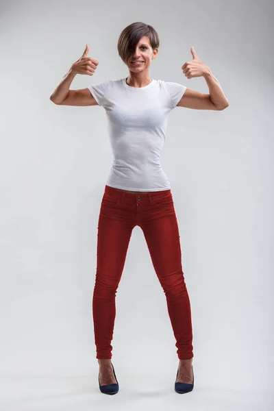 Exuding Optimism Woman Thumbs Gesture Her Red Jeans White Top — Stock Photo, Image