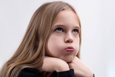 Thoughtful young girl with a pout, contemplating deeply with a whimsical expression clipart