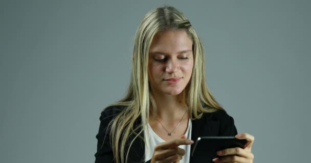 Die Junge Blonde Frau Benutzt Ein Smartphone Vor Neutralem Hintergrund — Stockvideo