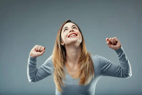 Jubilant Woman Grey Sweater Raises Her Fists Gesture Victory Strength — Stock Photo, Image