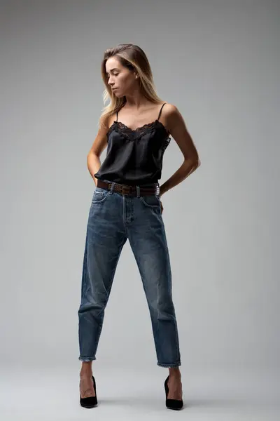 Elegante Sin Esfuerzo Postura Jeans Top Negro Encaje Transmite Una Imagen de archivo