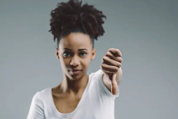 Afro Haired Woman Gives Thumbs Gesture Discerning Look Set Plain — Stock Photo, Image