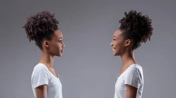 同じ黒人女性の2つの表現の間の視覚的な自己対話に判断と喜びが衝突する — ストック写真