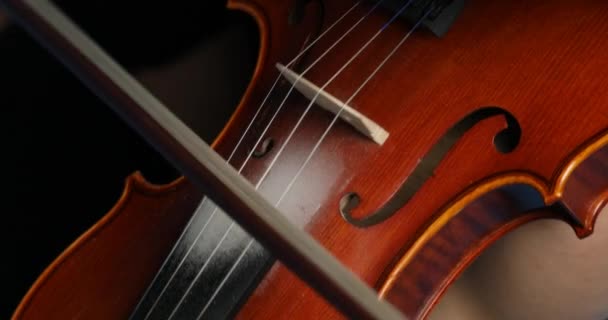 上から 映像はバイオリニストの手を撮影します 右手の弓と弦の左手の指 青い背景に古典的なコンサートのサウンドを生成します — ストック動画