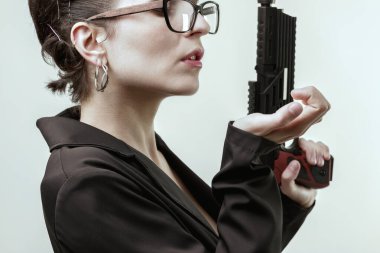 woman, embodying a novel's killer, holds a gun with confidence. Her smug expression and poised demeanor highlight her self-assured belief in being the best and her pride clipart