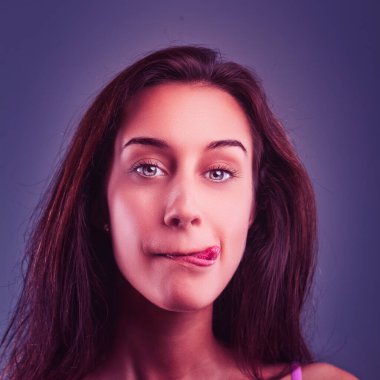 Portrait of a young woman biting her lip on a purple background, expressing a sense of doubt, insecurity, or playful hesitation clipart