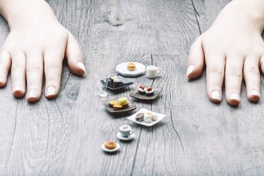 Mini portions of sushi, sandwiches, and desserts visually capture nutritional discipline challenges. Though accurate in size, these tempting treats feel too small and unsatisfying, yet visually appeal clipart