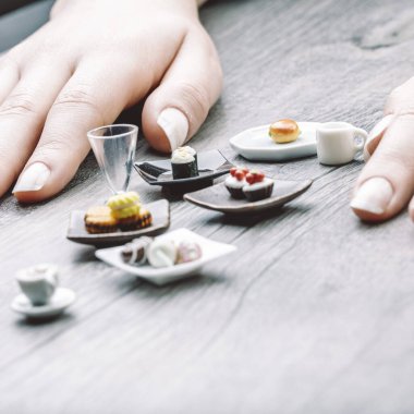 Miniature servings of coffee, pastries, and sushi illustrate portion control's tension between satisfaction and discipline. These visually appealing foods feel almost impossibly small clipart