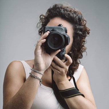 Photography instructor taking photos with professional camera, passing on knowledge to others during a photography class, sharing her expertise and passion for photography clipart