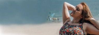 pozitif güzel ve iri yarı bir kadın sahilde eğleniyor.