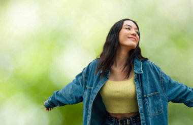 Rahat bir kız, kolları havada, sakince nefes alıyor.